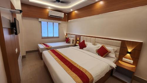 Cette chambre comprend deux lits et une télévision. dans l'établissement Hotel Priyadarsini, à Bānkura