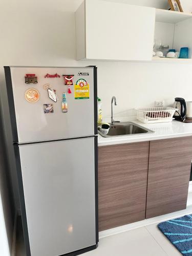 a refrigerator in a kitchen with magnets on it at Baan Tew Lom Condo บ้านทิวลมคอนโด in Cha Am