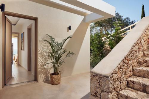 a staircase leading to a house with a plant at Thelxi's Suite II - Brand New Seaview Suite! in Volimes