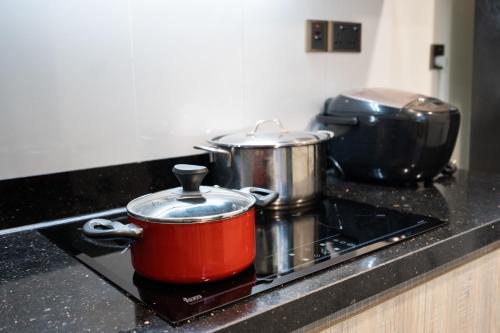 two pots and pans on a stove in a kitchen at DingD0ng Home FelizEnVista 5-star facilities in Ho Chi Minh City