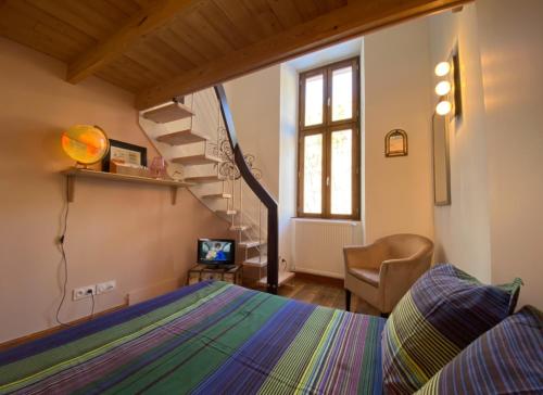 um quarto com uma cama e uma escada em espiral em Magnifique appartement 8 couchages dans villa historique em Jausiers