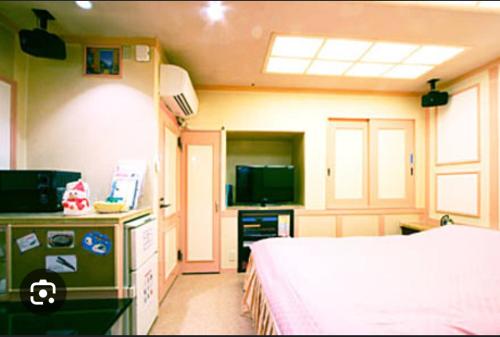 a bedroom with a bed and a tv in a room at 綾部アイネ in Ayabe