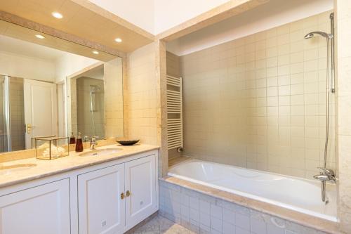 a bathroom with a tub and a sink at Aurelia Villa by CadenzaLux in Cascais