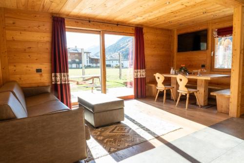 ein Wohnzimmer mit einem großen Fenster und einem Tisch in der Unterkunft Agriturismo La Stalla in Bormio