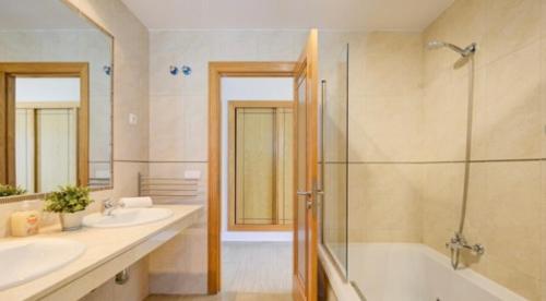 a bathroom with two sinks and a tub and a shower at CASA LOTTIE in La Guirra