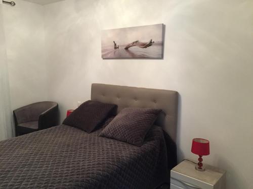 Un dormitorio con una cama y un cuadro en la pared. en Résidence Paolina, en LʼÎle-Rousse