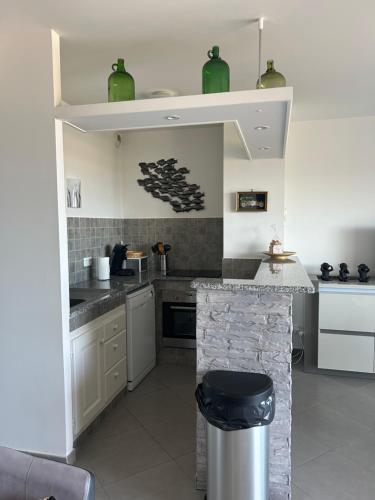 Una cocina con gabinetes blancos y encimera. en Résidence Paolina, en LʼÎle-Rousse