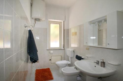 Baño blanco con aseo y lavamanos en Appartamento con Cortile Privato, en Santo Stefano di Camastra