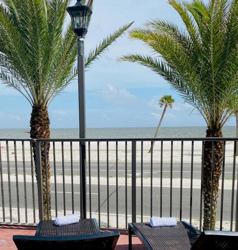 a balcony with two palm trees and a beach at Holiday Inn Express - Gulfport Beach by IHG in Gulfport