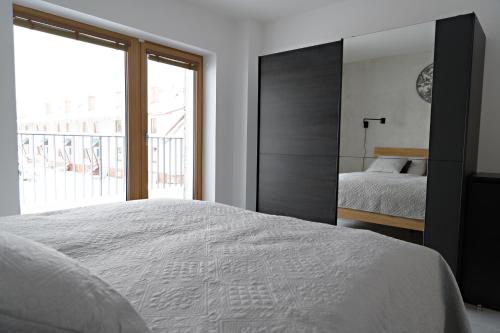 a bedroom with a bed and a large mirror at Apartmány StudenOFF in Rokytnice nad Jizerou