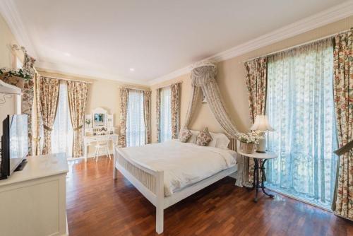 1 dormitorio con 1 cama con dosel en Rosario Oasis Resort SHA Plus en San Sai