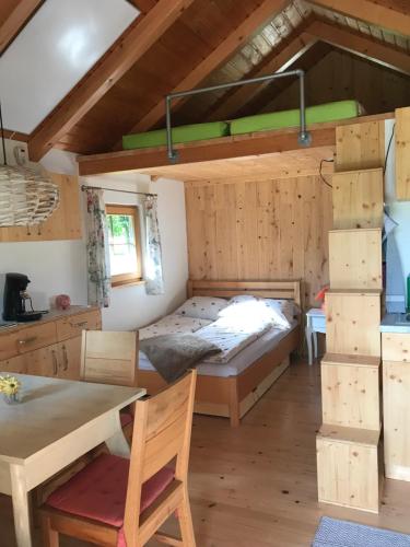 a room with a bed and a desk and a table at Tiny Home am Bach in Pettenbach