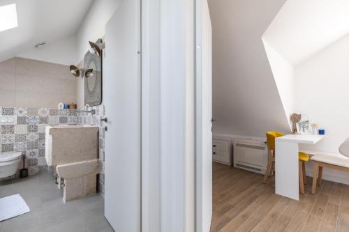 a white bathroom with a sink and a toilet at Villa Komelo in Škrip