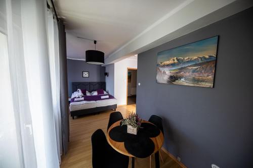 a room with a bed and a table and chairs at WRZOS resort & wellness in Węgierska Górka