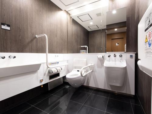 a bathroom with a toilet and a sink and a urinal at APA Hotel TKP Tokyo Nishi-Kasai in Tokyo