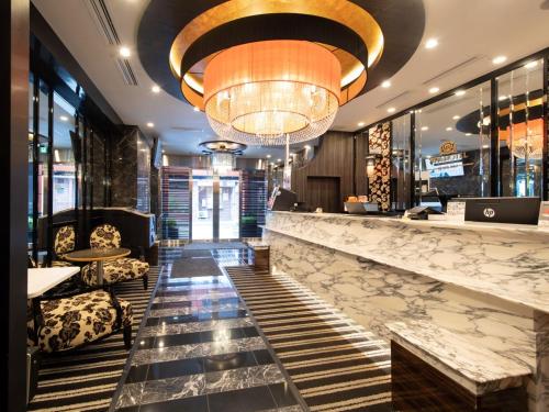 a lobby with a bar with a large chandelier at APA Hotel TKP Tokyo Nishi-Kasai in Tokyo