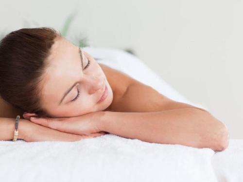 a woman laying on a bed with her eyes closed at APA Hotel TKP Tokyo Nishi-Kasai in Tokyo