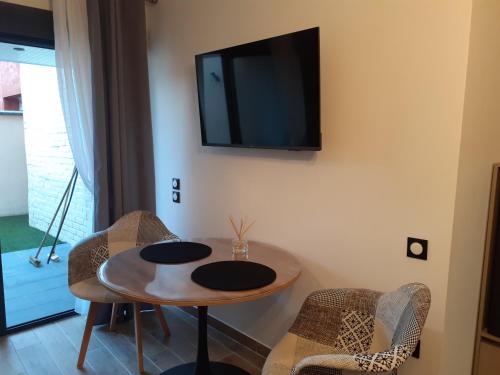 a room with a table and a tv on the wall at Lens Louvre 2 in Lens