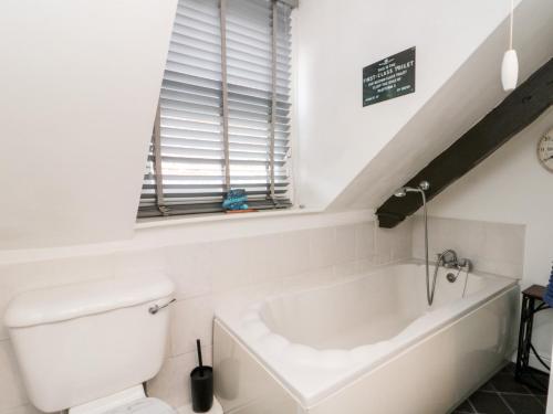 une salle de bain avec toilettes et baignoire dans l'établissement Black Sheep Cottage, à Thirsk