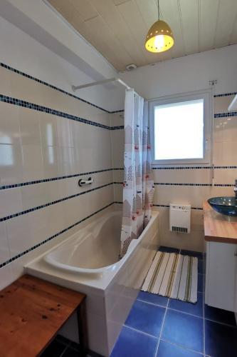 une salle de bain avec une baignoire et un lavabo dans l'établissement Capucines et agapanthes, à Saint-Nic