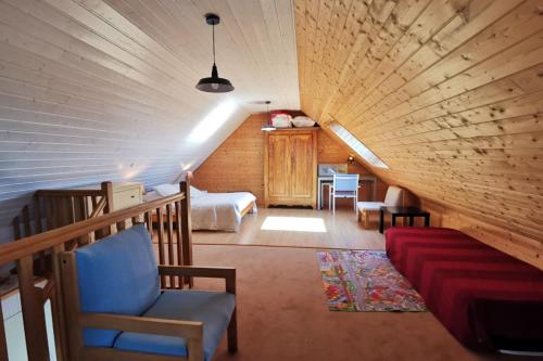 Cette chambre mansardée comprend un lit et un canapé. dans l'établissement Capucines et agapanthes, à Saint-Nic