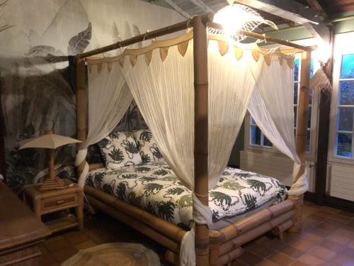une chambre avec un lit à baldaquin dans l'établissement Maison à 10 min du puy du fou et parc de Maulévrier, à Saint-Amand-sur-Sèvre