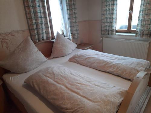a bedroom with two beds with white sheets and pillows at Asbichlerhof in Bad Endorf