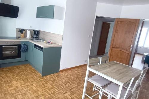 une cuisine avec une table et des chaises dans une pièce dans l'établissement l'étoile, le duplex, à Gravelines