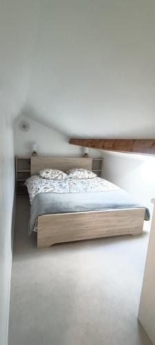 une chambre avec un lit dans une pièce blanche dans l'établissement l'étoile, le duplex, à Gravelines