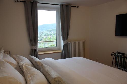 a bedroom with a bed and a large window at L'Escale de Beauregard in Coublevie