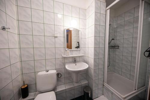 a white bathroom with a toilet and a sink at WRZOS resort & wellness in Węgierska Górka