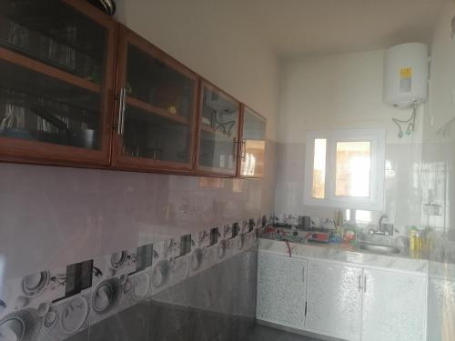 a kitchen with wooden cabinets and a sink at Jabal Shams bayt kawakib in Misfāh