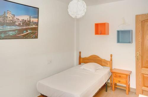 1 dormitorio con cama blanca, mesita de noche y cama sidx sidx sidx sidx en Apartamento amplio, en Sevilla