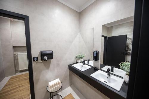 a bathroom with two sinks and a mirror at WRZOS resort & wellness in Węgierska Górka