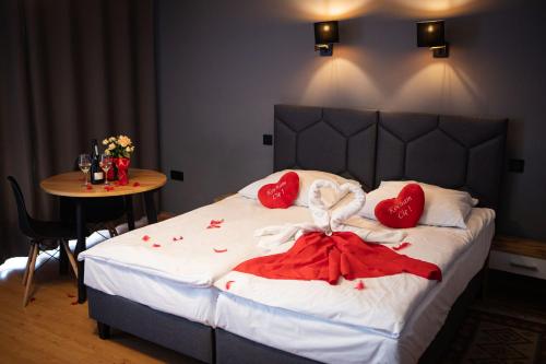a bed with red hearts on it with a table at WRZOS resort & wellness in Węgierska Górka