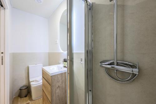 ein Bad mit einer Dusche und einem Waschbecken in der Unterkunft Encantador apartamento Plaza del Callao in Madrid