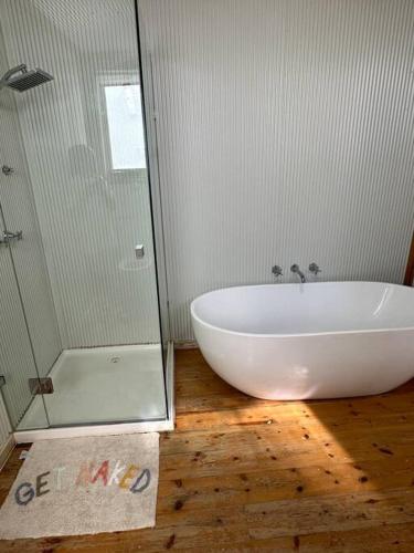 uma casa de banho com uma banheira e um chuveiro em vidro. em The Railway Parkview em Quarry Hill