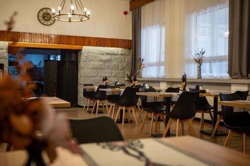 a dining room with tables and chairs and windows at WRZOS resort & wellness in Węgierska Górka