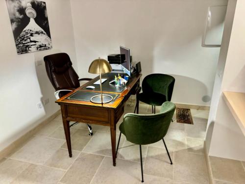 a desk with three chairs and a computer on it at Trulli Contento - Rooms & Apartments in Alberobello