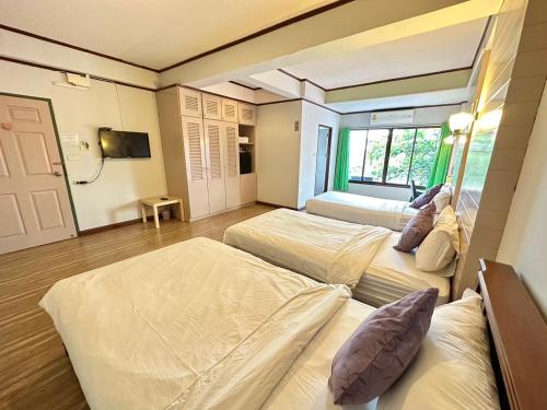 a bedroom with two beds and a tv in it at I Talay Lodge Botique hotel in Rayong