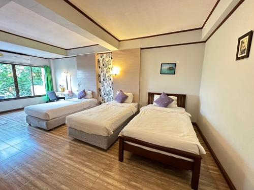 a hotel room with two beds and a couch at I Talay Lodge Botique hotel in Rayong
