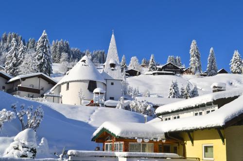 a village covered in snow with trees in the background at Alp-Chalet in Hirschegg