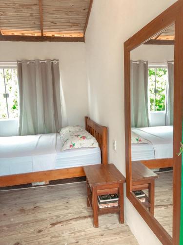 a bedroom with two beds and a mirror at Apto 1030 in Trancoso
