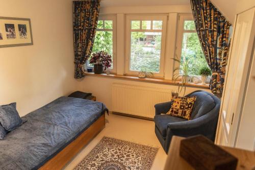 ein Schlafzimmer mit einem Bett, einem Sofa und einem Fenster in der Unterkunft Ferienhaus LANDHAUS STUHRBERG in Brake