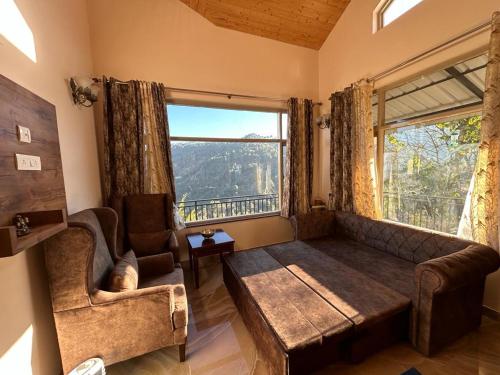 sala de estar con sofá y ventana grande en Idyllic Private Cottage w/King Bed + Mountain view en Kasauli