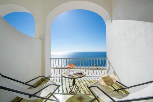 a balcony with two chairs and a table and the ocean at Il Barilotto in Positano