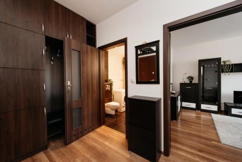 クラクフにある2-bedroom Apartment with garage in the city centerの木製キャビネット、バスルーム(トイレ付)が備わる客室です。