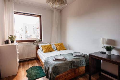 a bedroom with a bed with yellow pillows and a window at 2-bedroom Apartment with garage in the city center in Krakow