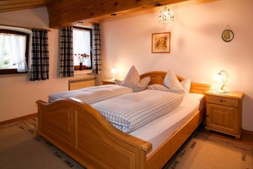 a bedroom with a wooden bed in a room at Ferienwohnungen Helga Mayer inkl. Chiemgaukarte in Ruhpolding