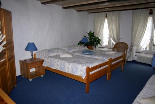 a bedroom with a large bed and two windows at Hotel zum alten Schweizer in Twann
